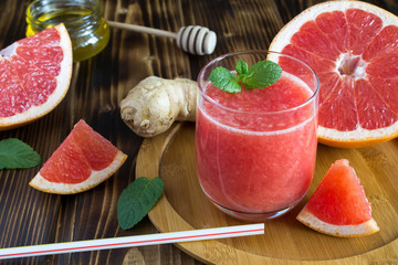 Grapefruit smoothie, ginger and honey on the wooden cutting board