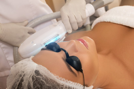 Beautiful woman in beauty salon during photo rejuvenation procedure