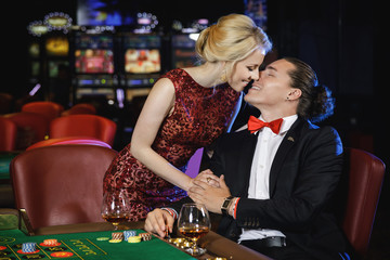 Beautiful and rich couple playing roulette in the casino