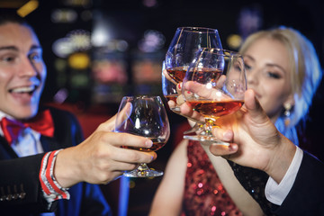  Hands with a full glasses of cognac.