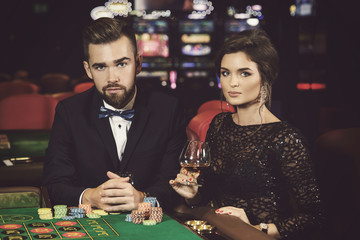 Beautiful and rich couple playing roulette in the casino