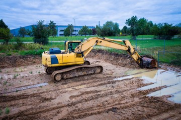 Yellow excavator on the tracks