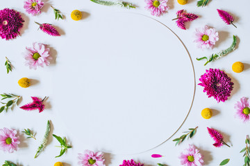 Fototapeta na wymiar A bright creative pattern of fresh flowers and leaves with copy space. Natural background. Frame of flowers. Flat lay.