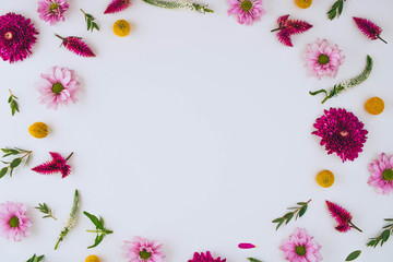 A bright creative pattern of fresh flowers and leaves with copy space. Natural background. Frame of flowers. Flat lay.
