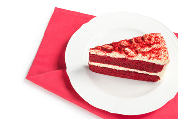 Red Velvet Cake sliced in piece on white plate over red placemat isolated on white background with Clipping Path for celebrate X'mas season, Valentines day or special holidays with copy space for text