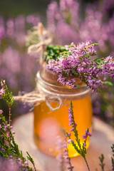 Honey. Jar with natural heather honey in heather bush