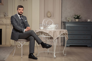 handsome old-fashioned bearded man sitting at the table