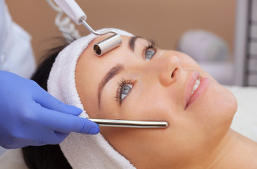 The cosmetologist makes the apparatus a procedure of Microcurrent therapy of a beautiful, young...