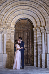 Bride and groom, outdoors, in romantic embrace