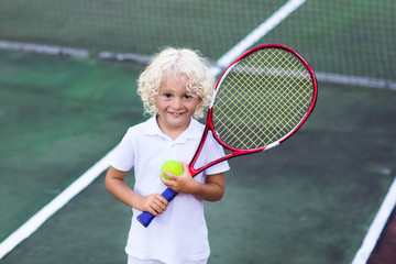 Child playing tennis on outdoor court