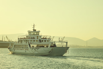 A large white ferry floats away into the distance. Water trail. Greece.
