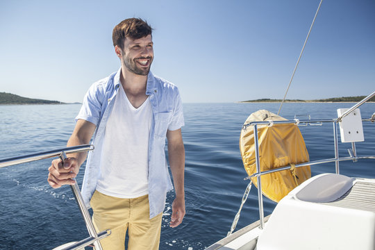 Man holding fast onto railing on sailboat, Adriatic Sea