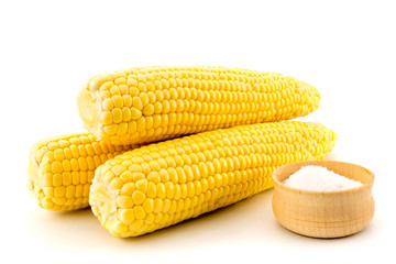 Ears of ripe corn with salt on white