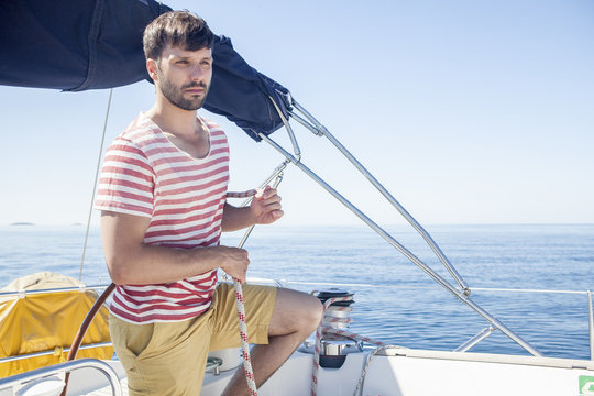 Young man overlooking sea on sailboat, Adriatic Sea