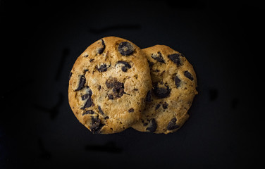 Chocolate chip cookies isolated on black background. Sweet biscuits. Homemade pastry.