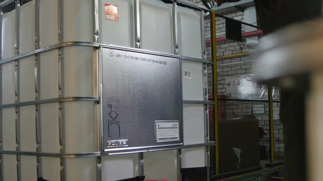 Backside View Worker Puts Metal Part on Container Frame