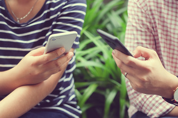 close up woman hand holding smartphone with friends for playing or communicate with others,teenager smart phone addiction concept
