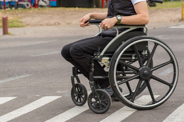Fototapeta premium Close-up of male on wheelchair, in zebra crossing in the streets of Quito