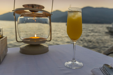 фужер с коктейлем на фоне заката на набережной 