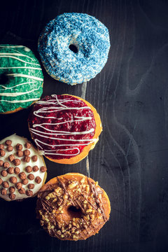 Sweet glazed donuts on the dark background with blank space