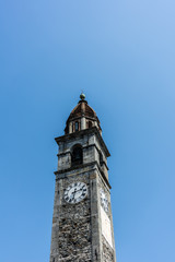 Historic Clock tower of Chiesa Parrocchiale dei Santi Pietro e Paolo Locarno, Switzerland with blue sky