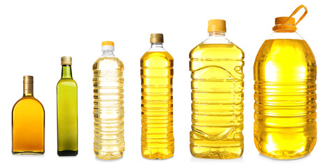 Different bottles with cooking oil on white background