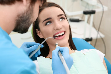 Dentist drilling patient's teeth in clinic