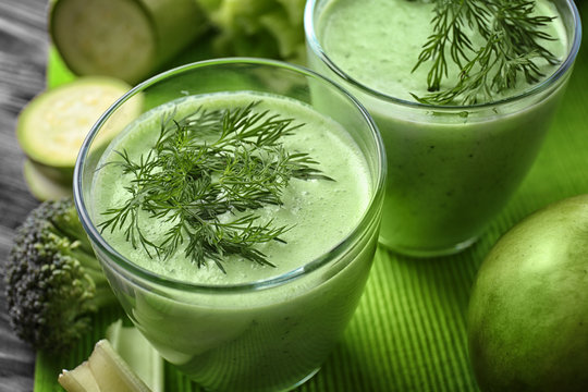 Glasses of green healthy juice on table, closeup