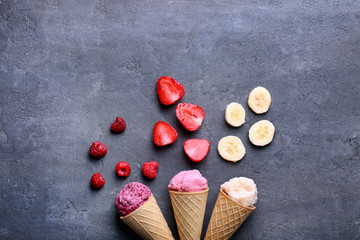 Cones with tasty yogurt ice cream on gray background