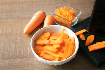 Bowl with sliced carrot on kitchen table