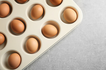 Muffin tin with hard boiled eggs on table