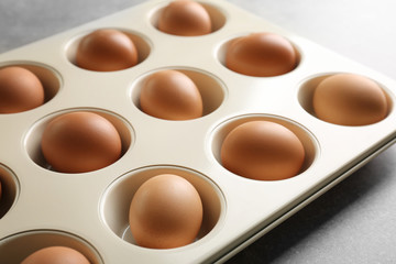 Muffin tin with hard boiled eggs on table