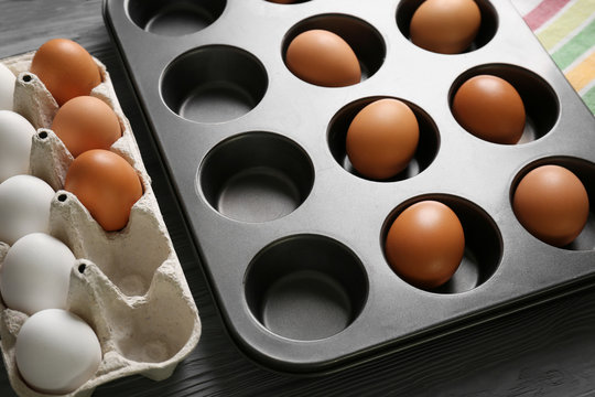 Muffin tin and holder with hard boiled eggs on table