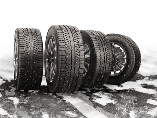 Four car tires rolling on a snow-covered road. © iaremenko