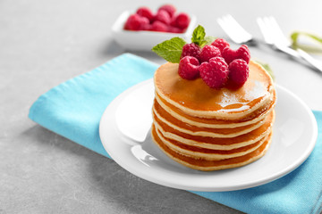 Delicious pancakes with raspberries on plate