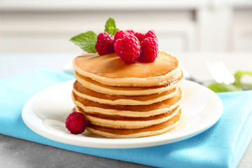 Delicious pancakes with raspberries on plate