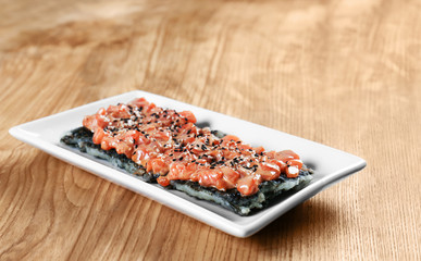 Fillet of salmon with rice and sesame seeds on table
