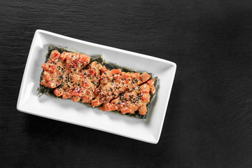 Fillet of salmon with rice and sesame seeds on table