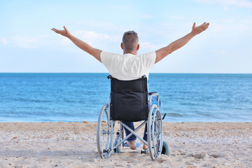 Elderly man in wheelchair on sea coast