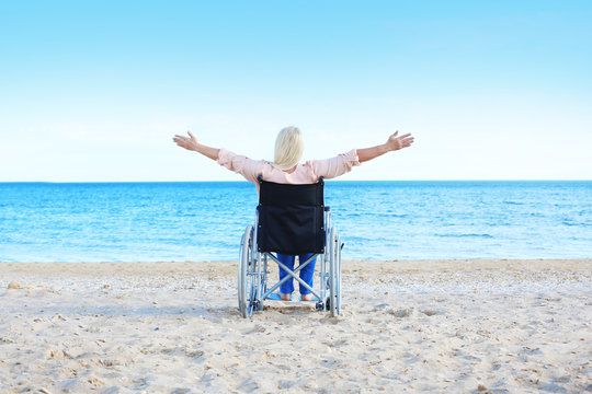 Elderly woman in wheelchair on sea coast