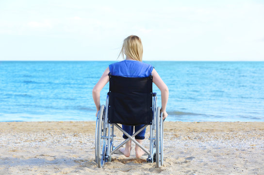 Young woman in wheelchair on sea coast