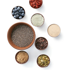 Composition with assortment of superfood products in bowls on white background, top view