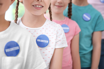 Children in shirts with volunteer buttons