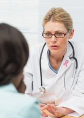 Doctor woman with breast cancer awareness ribbon and patient