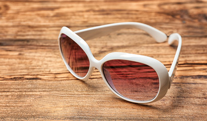 Beautiful sunglasses on wooden background