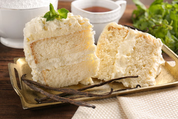 Pieces of delicious vanilla cake on table