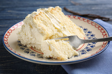 Piece of delicious vanilla cake on table