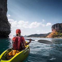 Foto op Canvas Woman paddles kayak in the calm sea among the tropical islands © Dudarev Mikhail