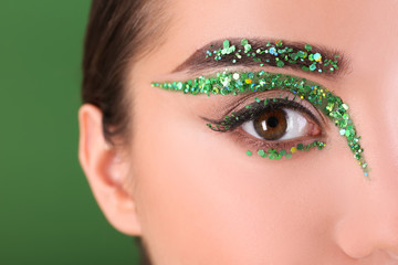 Naklejka premium Young woman with creative makeup on color background, close up