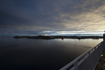 Sunset at the sea with smooth water and dramatic cloudy sky